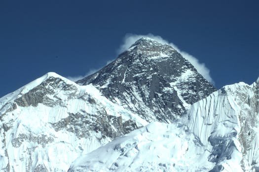 Majestic winter view of snow-covered Mount Everest under a clear blue sky, captured from Khumjung, Nepal.